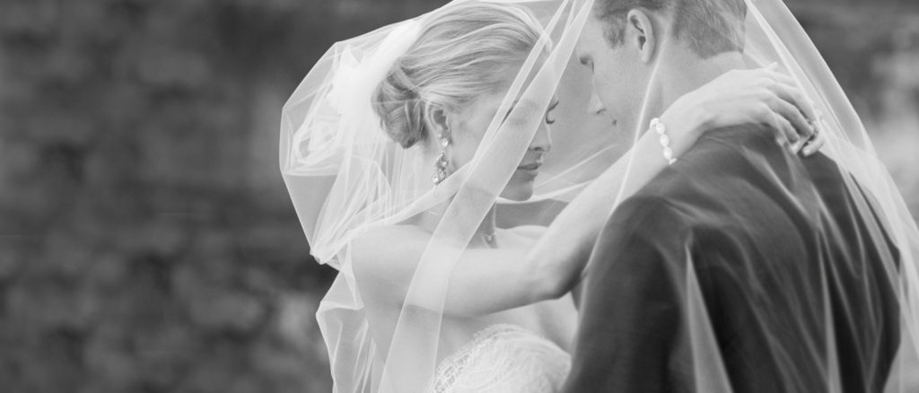 bride groom black white under veil